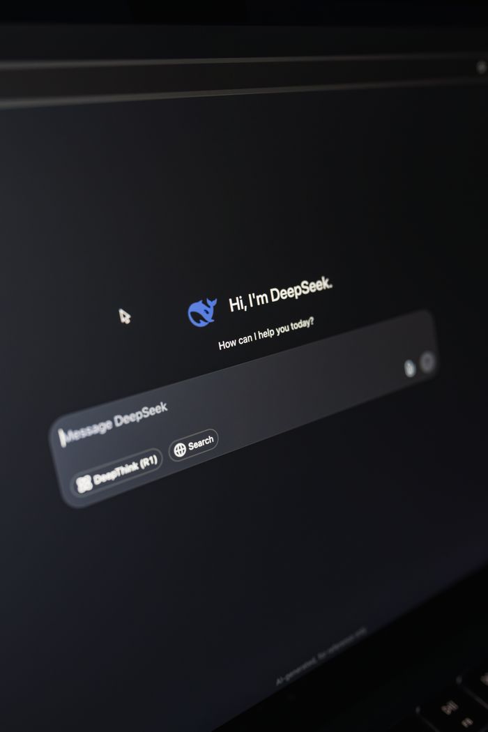 project-01-b Close-up of a laptop displaying an AI interface with a chatbot prompt in dark mode.